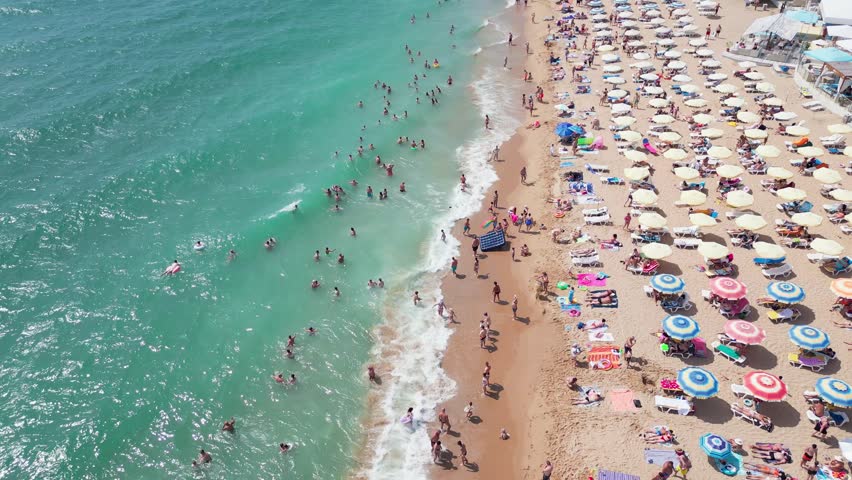 aerial view of Bulgaria's Golden Sands resort during the summer season: an array of hotels, pools, and crowds of people enjoying the sea. Royalty-Free Stock Footage #1106697145