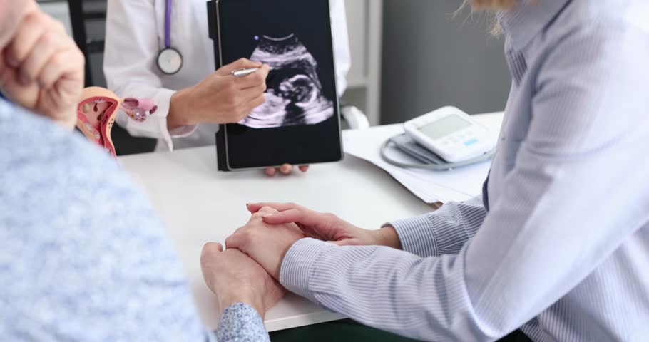 Gynecologist showing result of fetal ultrasound examination on digital tablet to married couple 4k movie Royalty-Free Stock Footage #1106697395