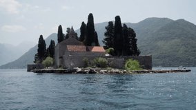 Video from the boat. The Catholic monastery of St. George, located on a small island in the Bay of Kotor near the city of Perast. Travel concept to Montenegro.