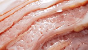 Delve into the world of raw bacon through a captivating macro lens. Glistening fat marbled within succulent meat, promising a delectable journey from pan to plate. Food concept. Bacon background
