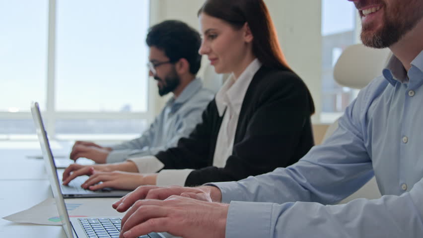 Row of diverse smiling business people businessmen and businesswoman typing on laptops professional colleagues team of technical support staff members work on desktop computers co-working office space Royalty-Free Stock Footage #1106705049