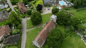 An arc shot of St Margaret of Antioch church and surrounding village houses.