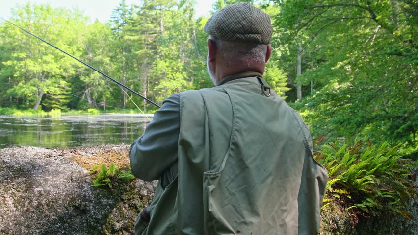 A fly fisherman getting ready to fish a beautiful trout stream. | Shutterstock HD Video #1106710347