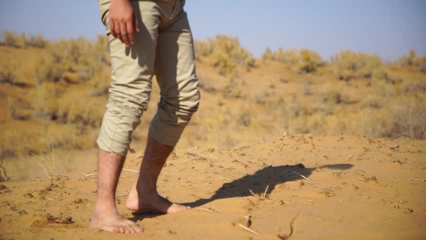 a man in a desert fall down near a lake