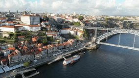 Drone shot flying right to left with bridge in view in Porto Portugal at sunset.