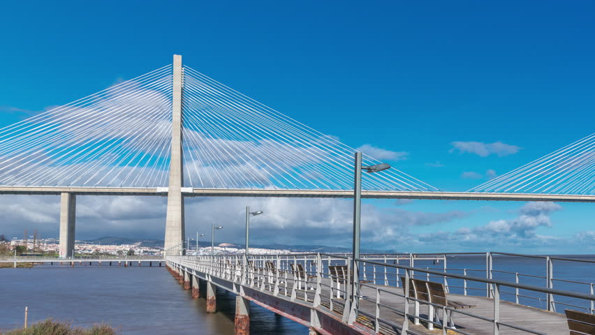 The Vasco da Gama Bridge timelapse hyperlapse with pier. Cable-stayed longest bridge flanked by viaducts and rangeviews that spans the Tagus River in Park of Nations in Lisbon, Portugal