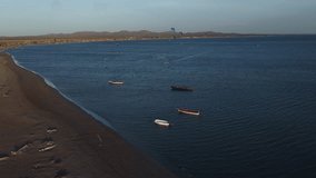 Camera circling Kite surfers and small fishing boats in the water at Cabo de la Vela Colombia Aerial video