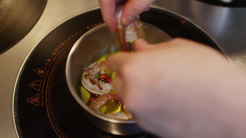 Preparing traditional Mediterranean seafood shrimp soup in a pot inside a professional restaurant kitchen 