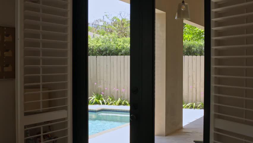 Miami, Florida, USA. Modern building with swimming pool, trees, chairs. Urban landscape with blue reflecting pool, city architecture, and scenic environment.