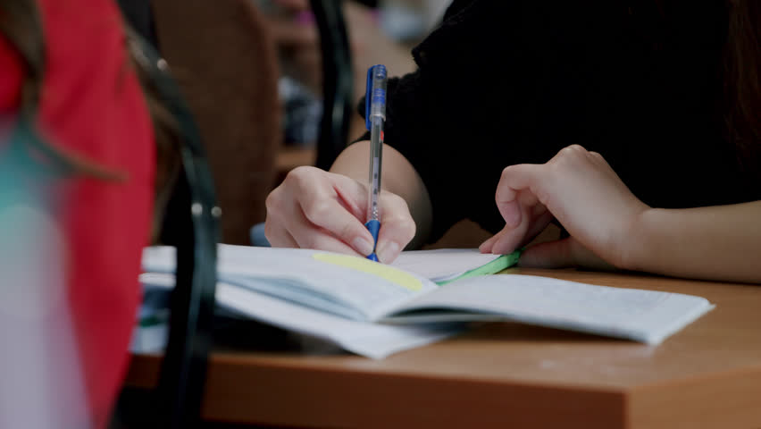 Close-up image of a student writing down information taught by the university professor in a notebook. The diligent student who makes notes with a pen during class. Concept of prestigious universities - Powered by Shutterstock - Get 15% off with code: PIKWIZARD15