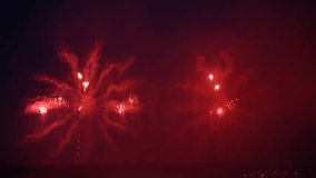 Beautiful firework explodes in night city sky above bridge. Real time video. Pyrotechnic display. Copy space for your text. Holiday celebration theme.