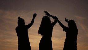 Silhouettes in summer sky. Group of people pray and bask in rays of sunset and sunrise. Raising hands to sky, prayer meeting at dawn in the summer. people unite at sunset and sunrise to worship God - Powered by Shutterstock - Get 15% off with code: PIKWIZARD15