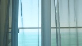 Beautiful Blue Ocean View Through the Window with White Transparent Curtains Slowly Swaying in the Wind. Resort, Apartment with Sea View. Leisure, Relax, Beauty, Travel. - Powered by Shutterstock - Get 15% off with code: PIKWIZARD15