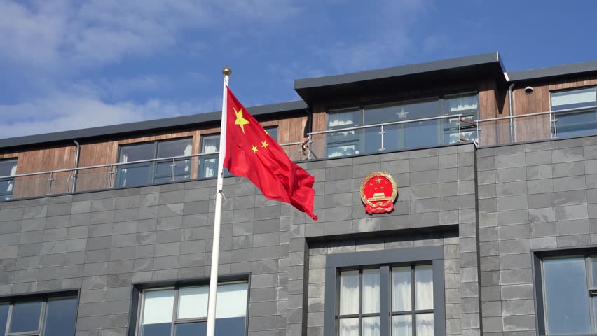 Waving Chinese flag and coat of arms at Chinese embassy building in Reykjavik, Iceland Royalty-Free Stock Footage #1106735209