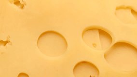 yellow cheese slices with large hole , rotation in circle. yellow cheese slice (edam, maaasdam), Turning. selective focus. Vertical video