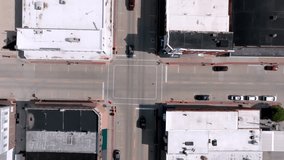 Downtown Geneseo, Illinois intersection with cars and drone video looking down stable wide shot.