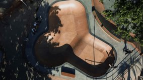 A teenage girl rides in a bowl of a skate park, shooting from above from a drone. Shadow from a teenager in the bowl of a skatepark, a girl performs tricks on a skateboard. - Powered by Shutterstock - Get 15% off with code: PIKWIZARD15