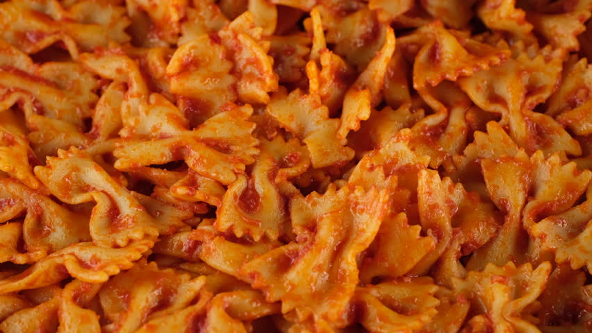 Pasta with tomato sauce and cheese. Chef sprinkle grated cheese on pasta. Cooking traditional italian dinner