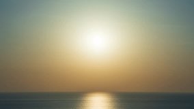 Time-lapse sunrise over beautiful hills or mountains horizon, dawn warm morning sunlight reflected on calm sea water surface. Bright hue orange sun rises behind mountain range silhouette skyline - Powered by Shutterstock - Get 15% off with code: PIKWIZARD15