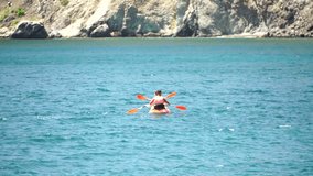 family kayaking in calm blue sea. Unrecognizable woman and man Kayak on turquoise sea water during warm day at sea. Summer holiday vacation and travel concept