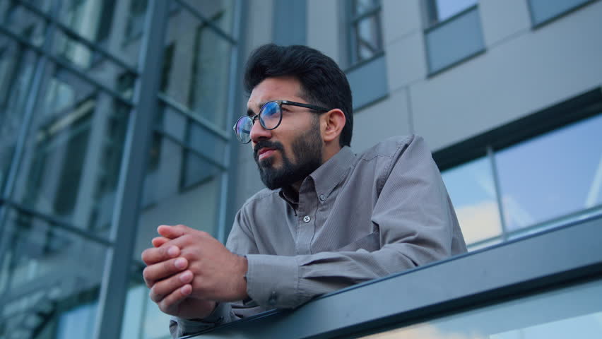 Sad thoughtful man Indian Arabian pensive businessman entrepreneur employer on terrace balcony outdoors depressed upset male worker in city concerned with business failure difficult decision crisis Royalty-Free Stock Footage #1106748963