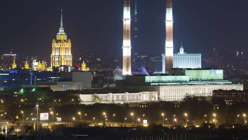 Evening view of the Hotel Ukraine and the Ostankin Tower between pipes from the observation deck on the Sparrow Hills in Moscow aerial timelapse. Night illumination