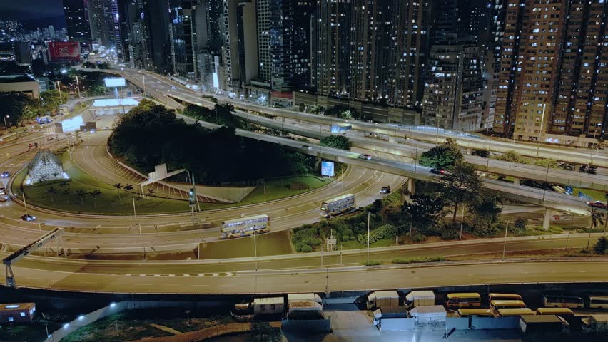 Aerial view over the roads and skyscrapers of the Central district on the harbour front on Hong Kong Island at night, Hong Kong, China. Drone dolly forward and tilt up shot