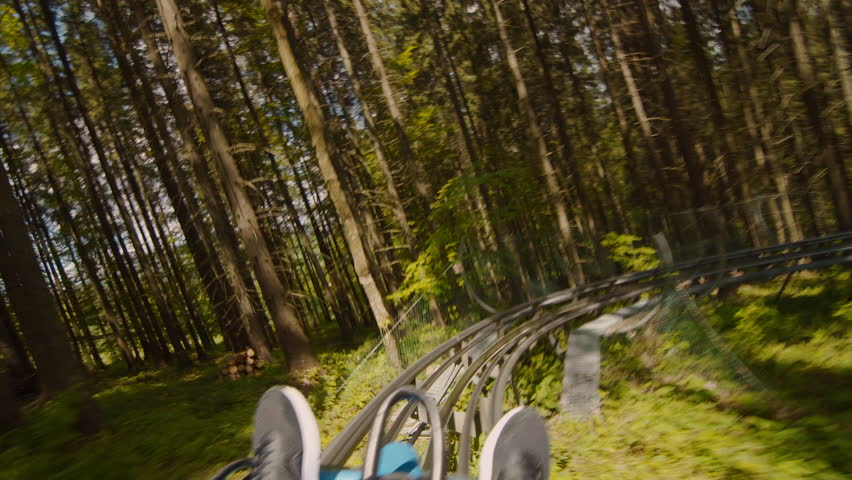 POV view in moving action unrecognizable man coming down a mountain roller coaster on a sunny day, outdoor adventure in the mountains 4K UHD B-Roll footage Royalty-Free Stock Footage #1106756271