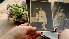 female hands holding paper envelope with old photographs, bouquet of wild flowers on table wooden table in garden, blurred natural background, concept of genealogy, memory of ancestors, family tree - Powered by Shutterstock - Get 15% off with code: PIKWIZARD15