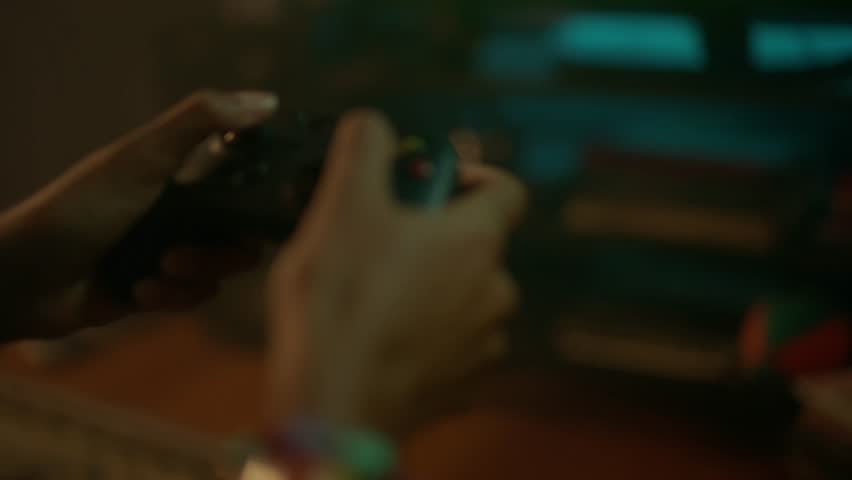 closeup of a person playing with joystick in hands, sitting on sofa at home