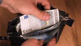 Man counting euros banknotes money in leather wallet and with tattooed hand he gives five euro bill to the hand of a girl. Euro currency Money concept for payment transactions for shopping and saving. - Powered by Shutterstock - Get 15% off with code: PIKWIZARD15