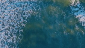 Beautiful texture of big power dark ocean waves with white wash. Aerial top view footage. Sea waves breaking over rocks. Aerial view of sand beach. Aerial vertical, vertical video background.