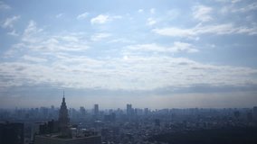 Time lapse footage with pan left motion of daytime cloudscape over metropolitan cityscape shot atop Tochou Capitol Government Building in Shinjuku, Tokyo, Japan
