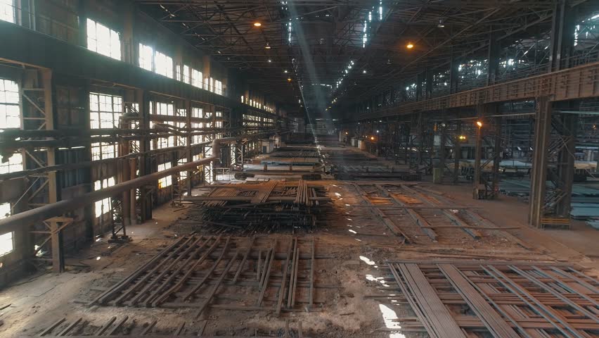 Span inside a large warehouse with metal blanks. A span inside a large metal workshop. Inside the workshop for the production of steel beams Royalty-Free Stock Footage #1106784121