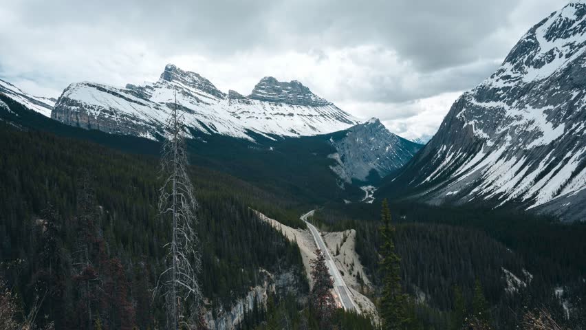 Timelapse of a Scenic drive on a beautiful highway, Icefields Parkway, through the Canadian Rockies during a vibrant summer day. Located in Banff National Park, Alberta, Canada.