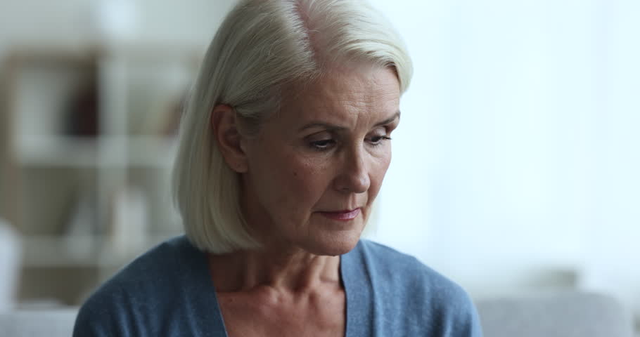 Stressed unhappy senior old woman feeling lost in thoughts, looking down, turning face away. Mature lady suffering from depression, apathy, mental disorder, going through crisis, stress Royalty-Free Stock Footage #1106786919