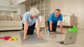 Fitness workout training. Senior adult mature healthy fit couple doing sports exercise on yoga mat on floor at home. Mid age old husband wife have training workout. Health care healthy lifestyle - Powered by Shutterstock - Get 15% off with code: PIKWIZARD15