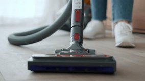 Video of close up of woman cleaning the living room floor with a vaccum cleaner