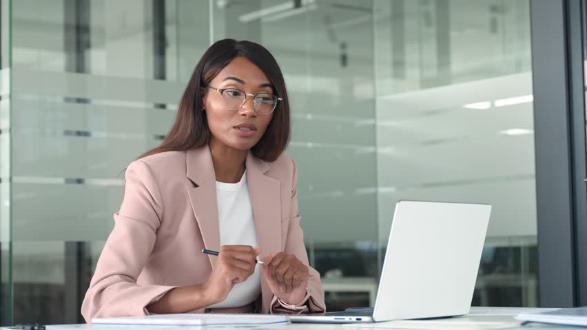 Professional young African American business woman hr manager team leader executive wearing suit, working in office looking at laptop having video conference call hybrid virtual online meeting. - Powered by Shutterstock - Get 15% off with code: PIKWIZARD15