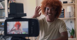 Young African American man recording video for social networks with a camera in an apartment. Digital content creator, streaming