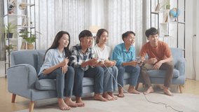 Asian Teenagers Playing Video Games And Celebrating Victory At Home
