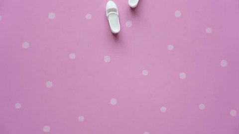 White doll shoes walking on a pink background. High quality 4K footage Stockvideo