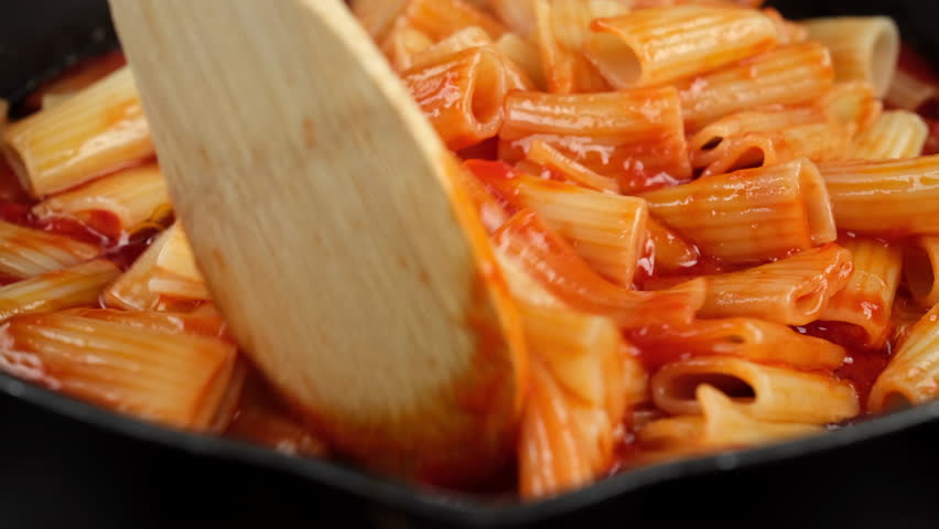 Chef stir pasta with boiling tomato sauce, close up. Cooking traditional Italian dinner pasta  Royalty-Free Stock Footage #1106800291
