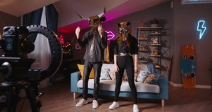 Two dancers record trending reels for followers In halloween masks unknown unrecognizable Bull and wolf masks Trending moving dance reel   app r Concept of virtual life