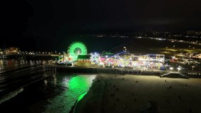 Establishing aerial shot of famous Santa Monica Pier at night of rides, ferris wheel and roller coaster - Powered by Shutterstock - Get 15% off with code: PIKWIZARD15