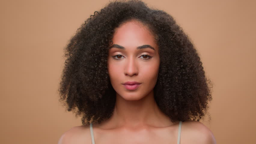 Beautiful young African American woman girl with perfect healthy smooth skin touching face beauty female portrait enjoying natural complexion anti aging skincare spa cosmetics product moisturizing