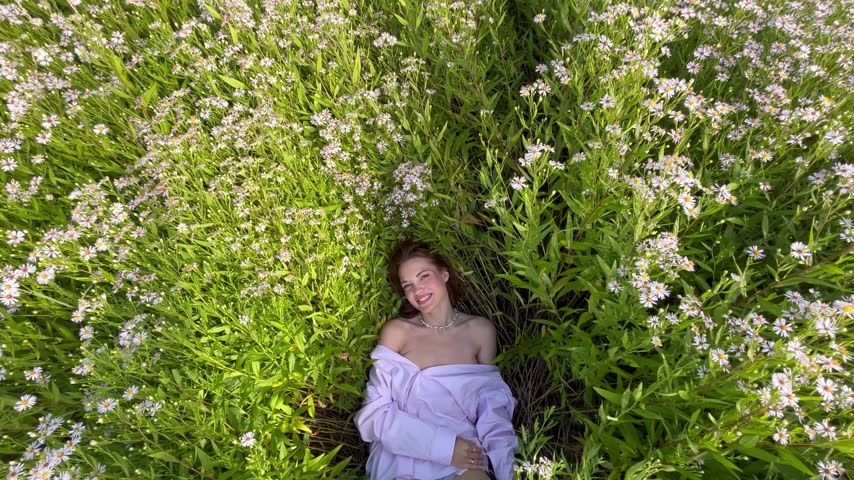 beautiful woman lies in the grass chamomile flowers happy summer. The concept of rest and new life of a woman.
