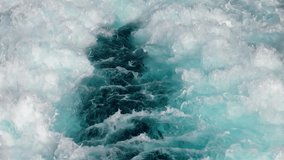 A close-up view of a powerful clear turquoise foaming waves and splashes in slow motion. Beautiful abstract texture on the surface of the water from fast boat movement. Seamlessly looped animation. - Powered by Shutterstock - Get 15% off with code: PIKWIZARD15