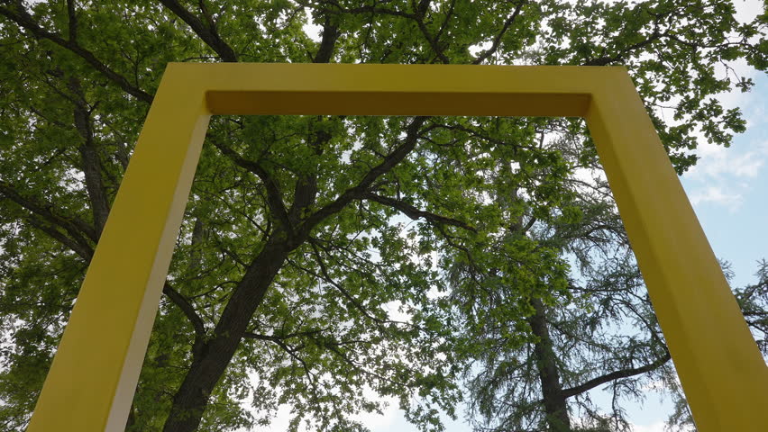 A yellow National Geographic frame on the front yard of the pink castle in the city in Estonia
