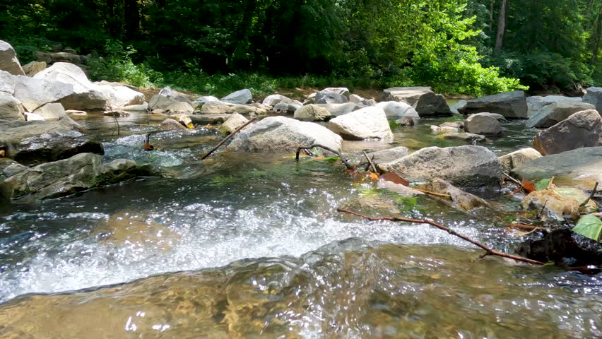Surface level views of a flowing river. The water sprays and splashes over the large rocks in the river. Located within Shawnee National Forest in Southern Illinois, USA.